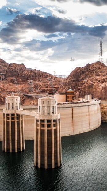 The Hoover Dam towers stand prominently above the calm water under a cloudy sky, HD Mobile Wallpaper