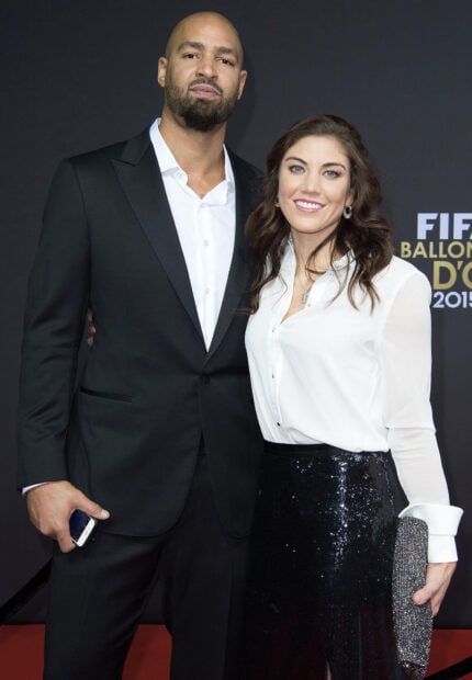 Hope Solo stands smiling beside a man in formal attire at an event, HD Desktop Wallpaper