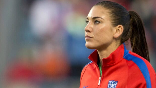 Hope Solo focused during a soccer match wearing a red jacket, HD Desktop Wallpaper