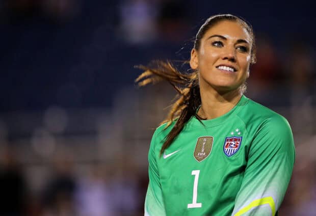 Hope Solo smiles confidently during a match wearing her green goalkeeper jersey, 2K Desktop Wallpaper