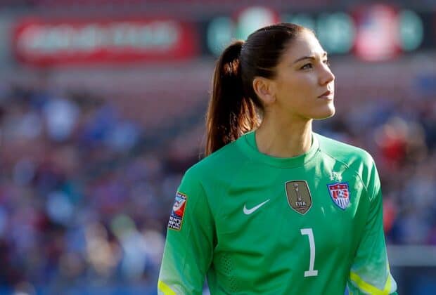 Hope Solo is looking intently during a soccer match wearing a green jersey, HD Desktop Wallpaper