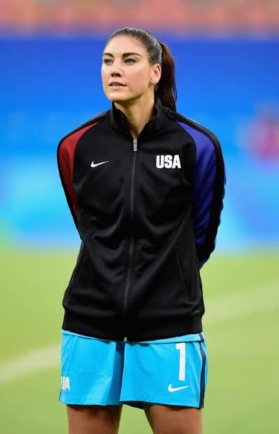Hope Solo is standing on the field wearing USA sportswear, 2K Mobile Wallpaper
