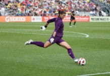 Hope Solo kicking a soccer ball during a match on the field, 2K Desktop Wallpaper