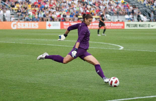 Hope Solo kicking a soccer ball during a match on the field, 2K Desktop Wallpaper