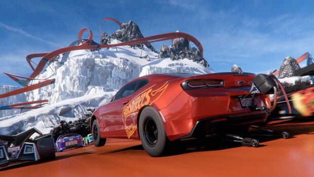 A Hot Wheels car races on an orange track winding through snowy mountains, 4K Desktop Wallpaper