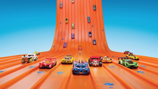 Hot Wheels race cars compete on a bright orange track under a clear sky, HD Desktop Wallpaper