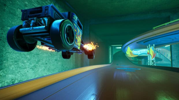 A Hot Wheels car is performing a fiery jump on a detailed toy track with a checkpoint ahead, 2K Desktop Wallpaper