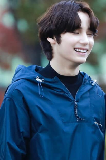 Huening Kai Wallpapers shows a radiant smile while wearing a blue jacket outdoors, HD Mobile Wallpaper