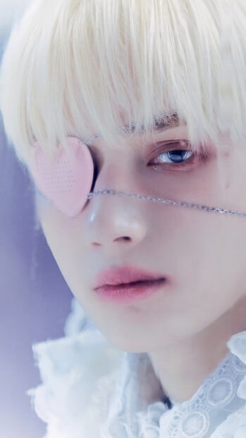 A close up portrait of Huening Kai with a pink heart eye patch and blonde hair, 4K Phone Wallpaper