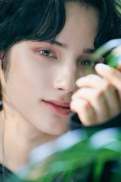 A close up portrait of Huening Kai with green eyes and soft expression, HD Phone Wallpaper