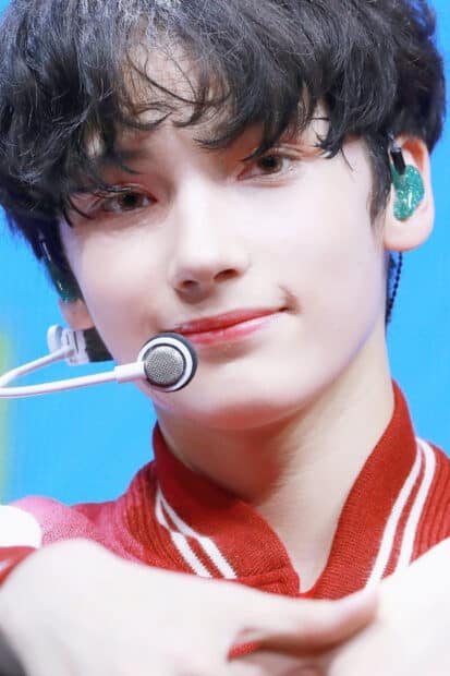 A close up portrait showing Huening Kai with a smile and microphone, HD Phone Wallpaper