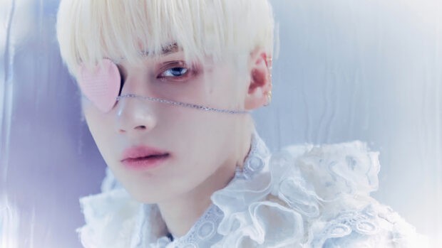 Huening Kai displays a thoughtful expression with a heart shaped eye patch, 4K Desktop Wallpaper