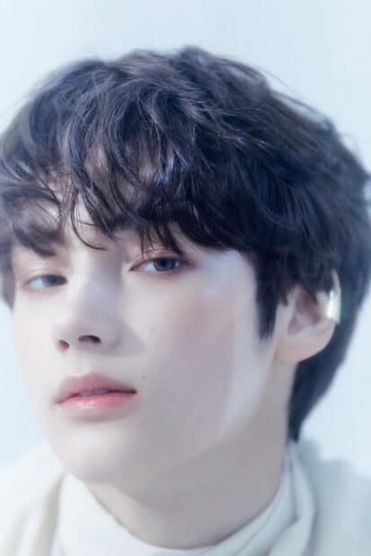 Huening Kai shows a serene expression with soft lighting on his face, HD Mobile Wallpaper