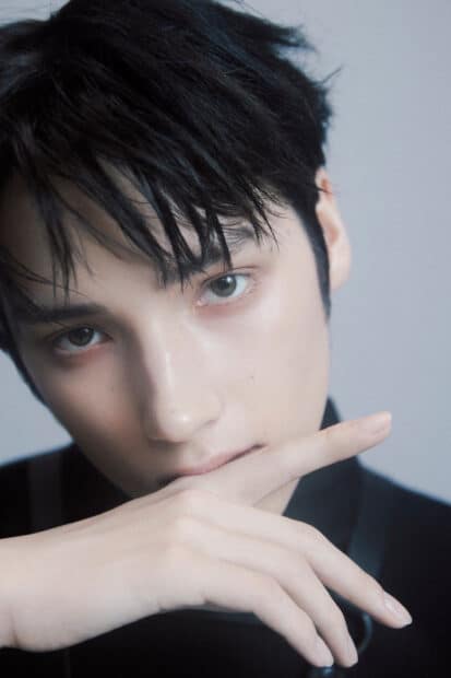 Huening Kai Wallpapers shows an intense close up portrait with his hand near his face, HD Mobile Wallpaper
