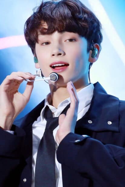 Huening Kai is singing on stage with microphone and earpiece, HD Mobile Wallpaper