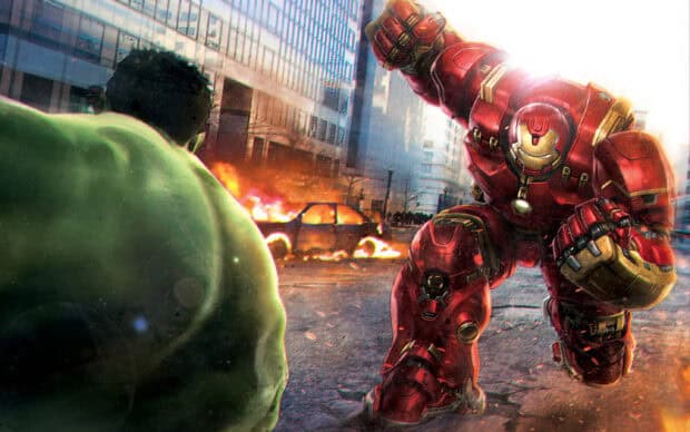 Hulkbuster charges at Hulk in a city street with burning cars in the background, 2K Desktop Wallpaper