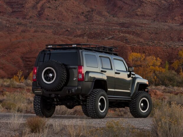 A Hummer H3 is parked on a dirt road with red rock formations and autumn foliage in the background, HD Desktop Wallpaper