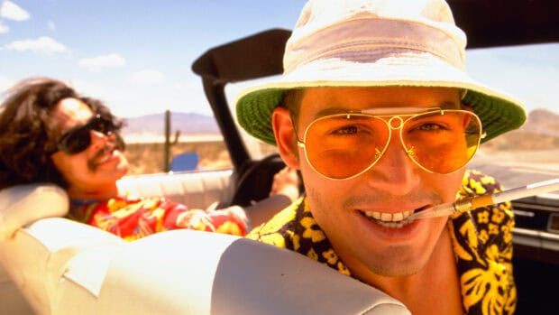 A close up of Hunter S Thompson wearing yellow glasses and a hat on a desert road trip, HD Desktop Wallpaper