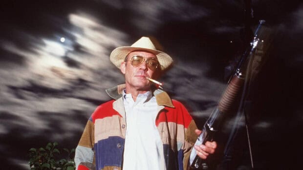 A man holding a shotgun wears a colorful jacket and hat under a moonlit cloudy sky in Hunter S Thompson Wallpapers, HD Desktop Wallpaper