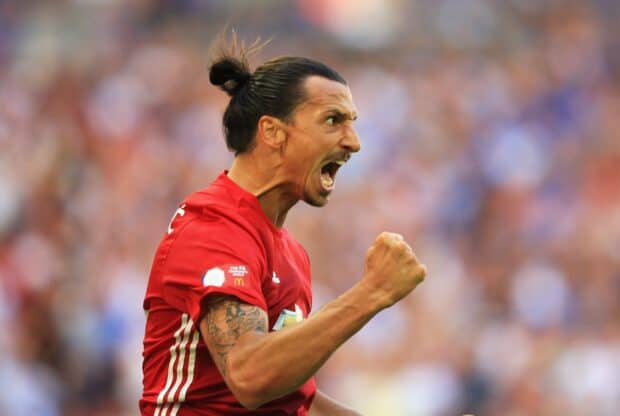 Ibrahimovic in a red jersey celebrates passionately during a match, HD Desktop Wallpaper
