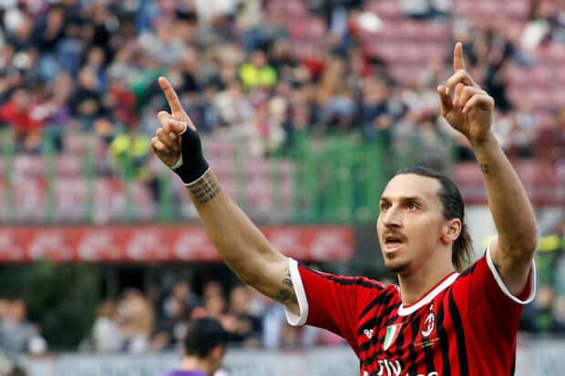 Zlatan Ibrahimovic raises his hands during a match in a red and black AC Milan jersey, HD Desktop Wallpaper