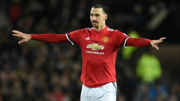 Zlatan Ibrahimovic stretches his arms during a match in a red Manchester United jersey, HD Desktop Wallpaper