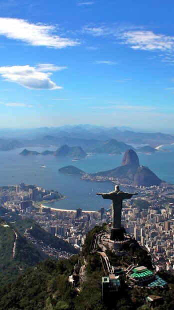 The Christ the Redeemer statue overlooks the city of Rio de Janeiro surrounded by mountains and water, HD Phone Wallpaper