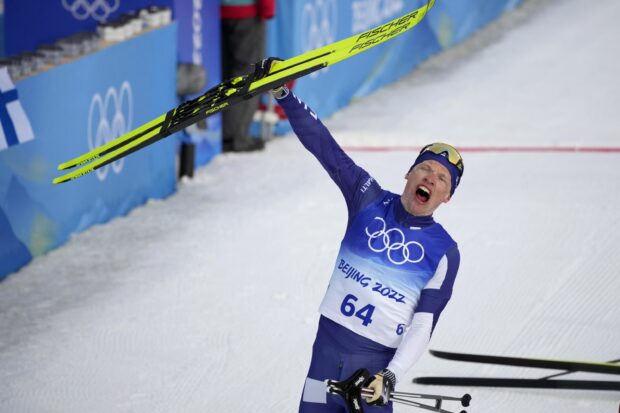 Iivo Niskanen raises skis after winning a race at the Beijing 2022 Olympics, 2K Desktop Wallpaper