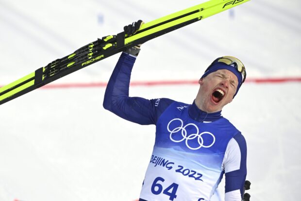 Iivo Niskanen shows excitement holding skis at a winter sports event, 2K Desktop Wallpaper