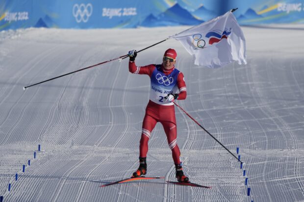 Iivo Niskanen is skiing and holding the Olympic flag at the Beijing 2022 event, 2K Desktop Wallpaper