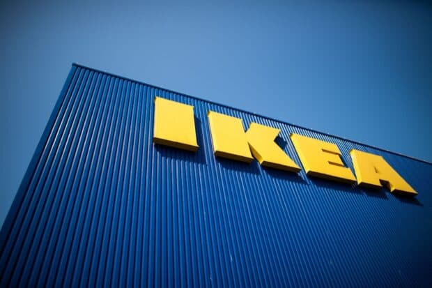 The Ikea logo in yellow letters is displayed on a blue corrugated metal wall under clear skies, HD Desktop Wallpaper