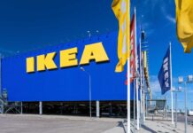 The Ikea store facade with large yellow letters under a clear blue sky featuring Ikea flags, HD Desktop Wallpaper