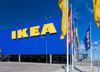 The Ikea store facade with large yellow letters under a clear blue sky featuring Ikea flags, HD Desktop Wallpaper