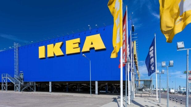 The Ikea store facade with large yellow letters under a clear blue sky featuring Ikea flags, HD Desktop Wallpaper