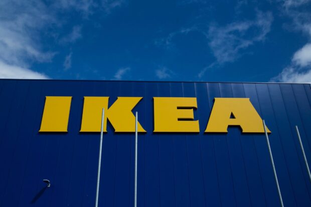 The Ikea wallpapers store sign stands clearly against a bright cloudy sky, 2K Desktop Wallpaper