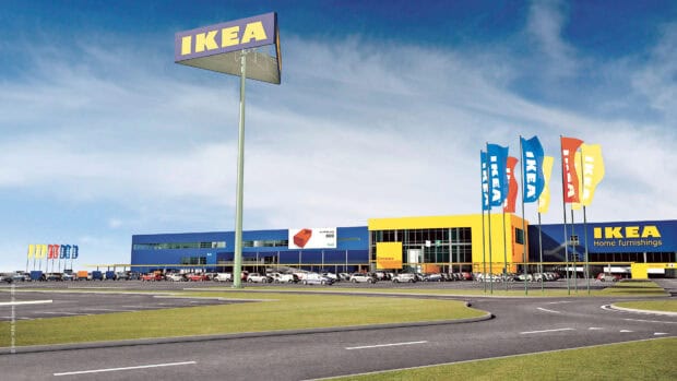 The Ikea store with colorful flags and cars parked in front under a cloudy sky, 4K Desktop Wallpaper