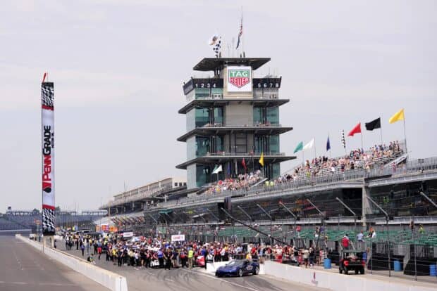 A crowded pit lane and grandstand at Indianapolis Motor Speedway during a racing event, 2K Desktop Wallpaper