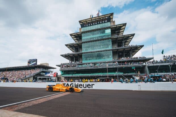 A race car speeds past the grandstands at Indianapolis Motor Speedway during an event, 2K Desktop Wallpaper