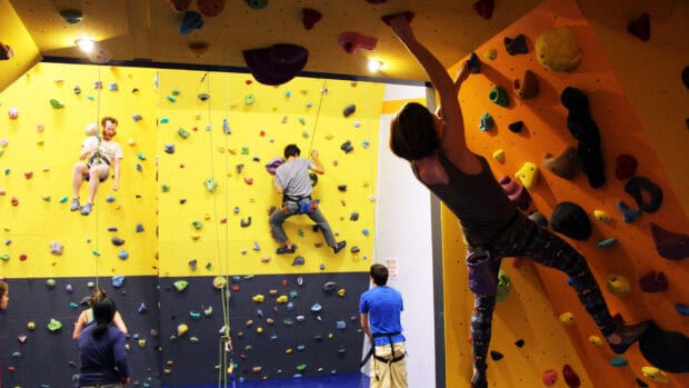 People practicing rock climbing on indoor walls with colorful holds, HD Desktop Wallpaper