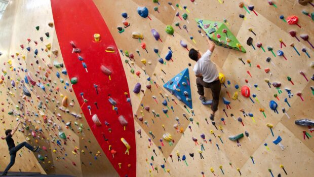 Rock climbing walls with colorful grips and climbers indoors, HD Desktop Wallpaper