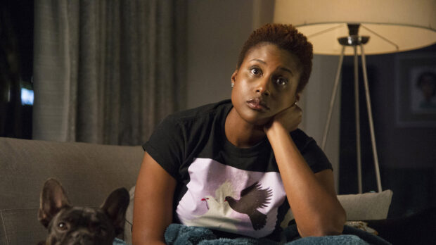 A woman from Insecure TV series sits thoughtfully on a couch with a dog nearby, 2K Desktop Wallpaper