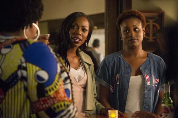 Two women from Insecure TV series having a conversation in a cozy bar setting, 2K Desktop Wallpaper