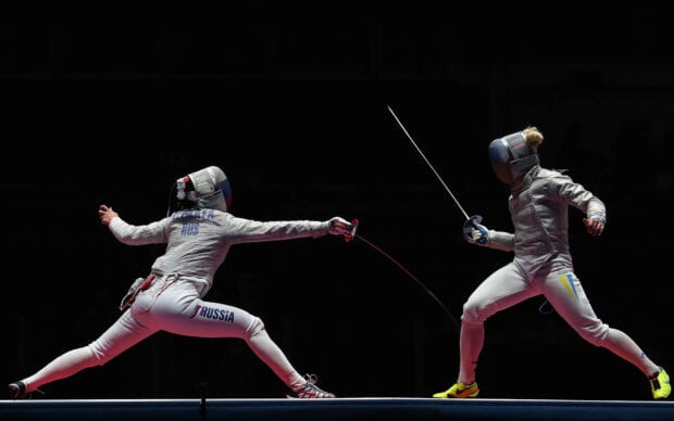 Two athletes compete in a fencing duel under bright lights, HD Desktop Wallpaper