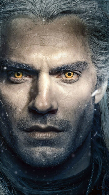 A close up of a fantasy warrior with yellow eyes in a snowy setting from The Witcher Tv Series wallpapers, 2K Phone Wallpaper