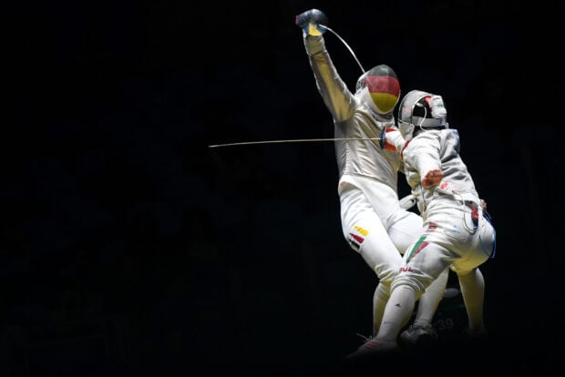 Two fencers compete fiercely in a dynamic move during a fencing match, HD Desktop Wallpaper
