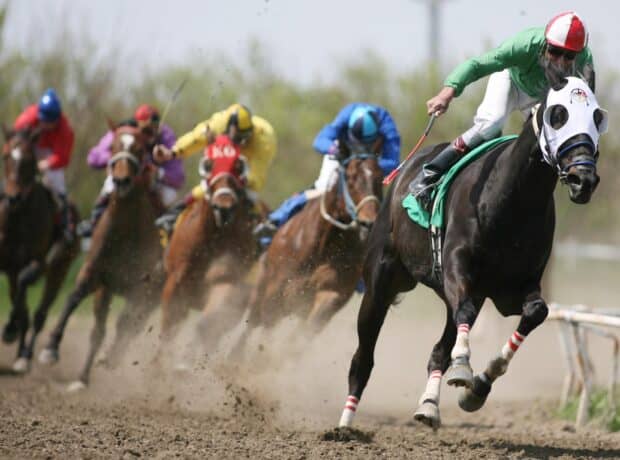 A thrilling horse racing scene with jockeys competing fiercely in a dirt race, HD Desktop Wallpaper