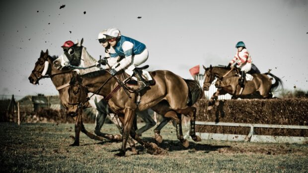 Jockeys riding horses in an intense horse racing competition on a grass track, 2K Desktop Wallpaper