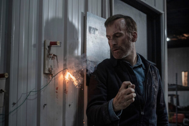 Bob Odenkirk lighting a fuse with sparks in a dramatic scene, HD Desktop Wallpaper