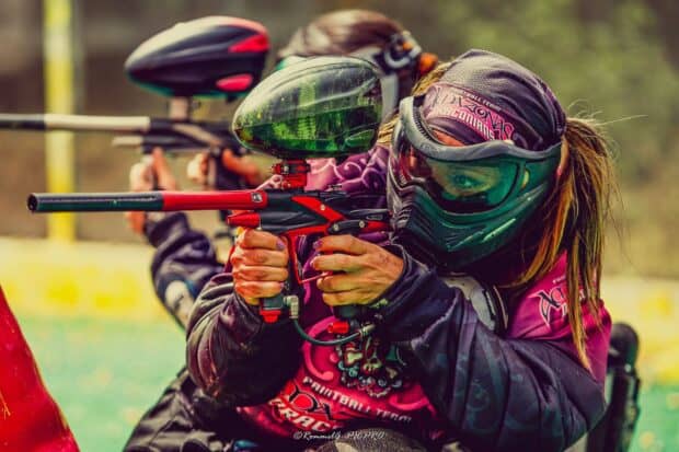 Two players aiming paintball markers in a competitive match, HD Desktop Wallpaper