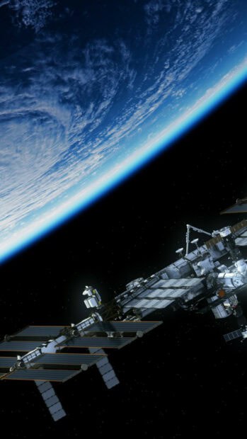 The space station orbits Earth against a backdrop of stars and clouds, HD Phone Wallpaper